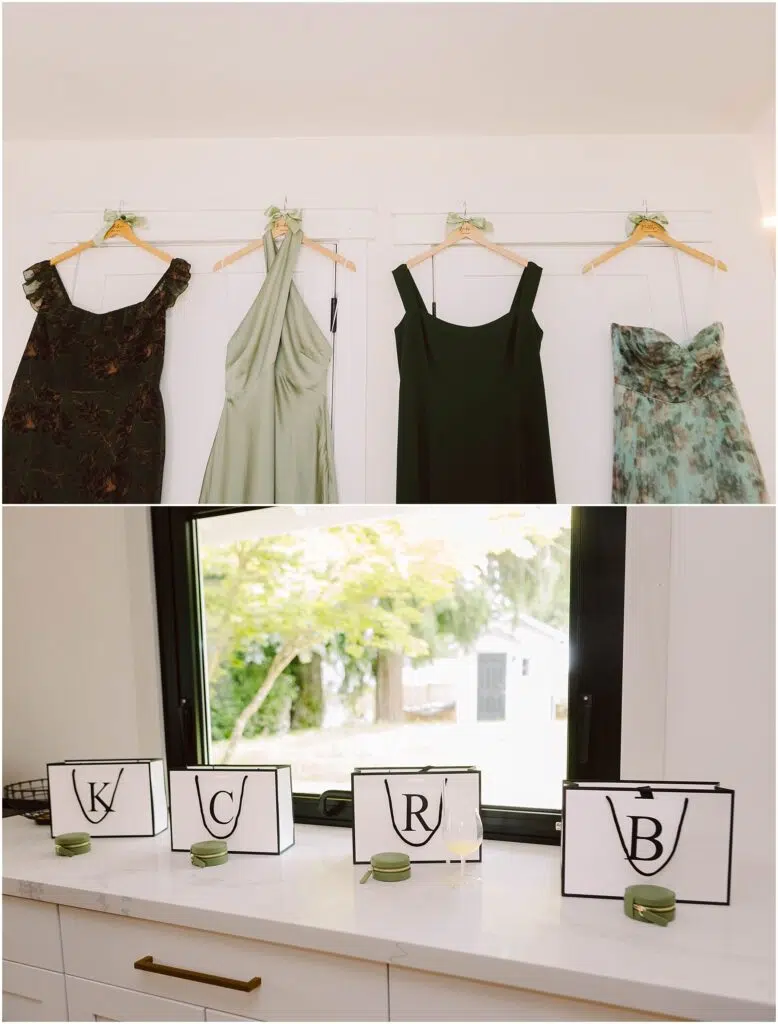 Snohomish Wedding Photographer GSquared Weddings Four dresses hang on a wall: a dark patterned one, a light green, a black, and floral—perfect for a summer wedding in Port Gamble. Below, four black-edged placards with the letters K, C, R, and B adorn the countertop with small green candles beside each. Serving Seattle, Snohomish and Washington State