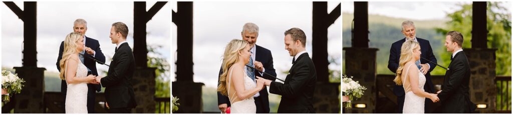 Snohomish Wedding Photographer GSquared Weddings A couple in wedding attire shares a joyful moment while exchanging vows at a picturesque winery. A man stands behind them officiating the ceremony amidst lush greenery and charming wooden structures. Serving Seattle, Snohomish and Washington State