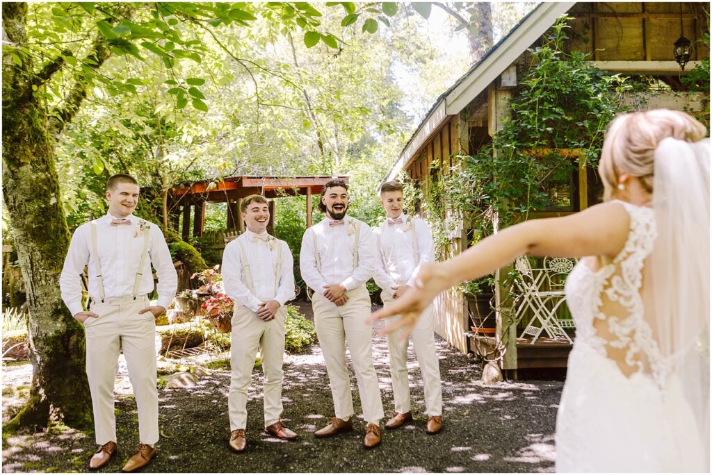 Snohomish Wedding Photographer GSquared Weddings A bride seen from behind approaches four groomsmen in matching beige pants and white shirts all smiling at her They stand under lush green trees next to a rustic wooden building on a sunny Snohomish day Serving Seattle Snohomish and Washington State Snohomish Wedding Photographer GSquared Weddings A bride, seen from behind, approaches four groomsmen in matching beige pants and white shirts, all smiling at her. They stand under lush green trees next to a rustic wooden building on a sunny Snohomish day. Serving Seattle, Snohomish and Washington State