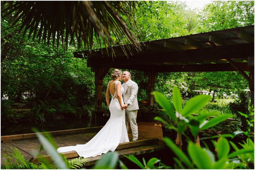 Snohomish Wedding Photographer GSquared Weddings A bride and groom stand together under a wooden gazebo in Snohomish surrounded by lush greenery The bride wears a long white dress with a flowing train while the groom is in a lightcolored suit They hold hands and gaze at each other lovingly Serving Seattle Snohomish and Washington State Snohomish Wedding Photographer GSquared Weddings A bride and groom stand together under a wooden gazebo in Snohomish, surrounded by lush greenery. The bride wears a long white dress with a flowing train, while the groom is in a light-colored suit. They hold hands and gaze at each other lovingly. Serving Seattle, Snohomish and Washington State