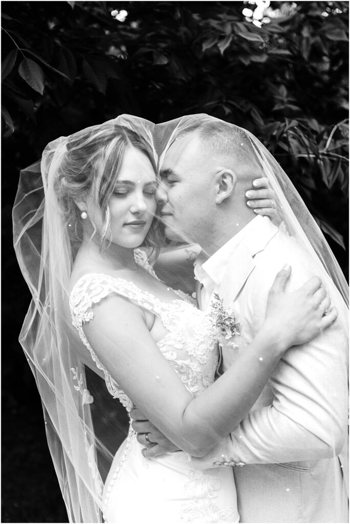 Snohomish Wedding Photographer GSquared Weddings Black and white photo of a couple embracing on their wedding day in Snohomish The bride is in a lace gown and veil while the groom sports a lightcolored suit Theyre surrounded by leafy trees creating a romantic intimate moment Serving Seattle Snohomish and Washington State Snohomish Wedding Photographer GSquared Weddings Black and white photo of a couple embracing on their wedding day in Snohomish. The bride is in a lace gown and veil, while the groom sports a light-colored suit. Theyre surrounded by leafy trees, creating a romantic, intimate moment. Serving Seattle, Snohomish and Washington State
