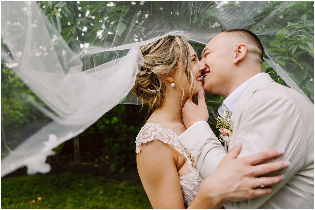 Snohomish Wedding Photographer GSquared Weddings Bride and groom sharing a joyful moment outdoors in Snohomish The brides veil drapes over them as they lean in for a kiss smiling warmly The groom holds the brides face amid the lush greenery that beautifully defines this picturesque setting Serving Seattle Snohomish and Washington State Snohomish Wedding Photographer GSquared Weddings Bride and groom sharing a joyful moment outdoors in Snohomish. The bride’s veil drapes over them as they lean in for a kiss, smiling warmly. The groom holds the bride’s face amid the lush greenery that beautifully defines this picturesque setting. Serving Seattle, Snohomish and Washington State