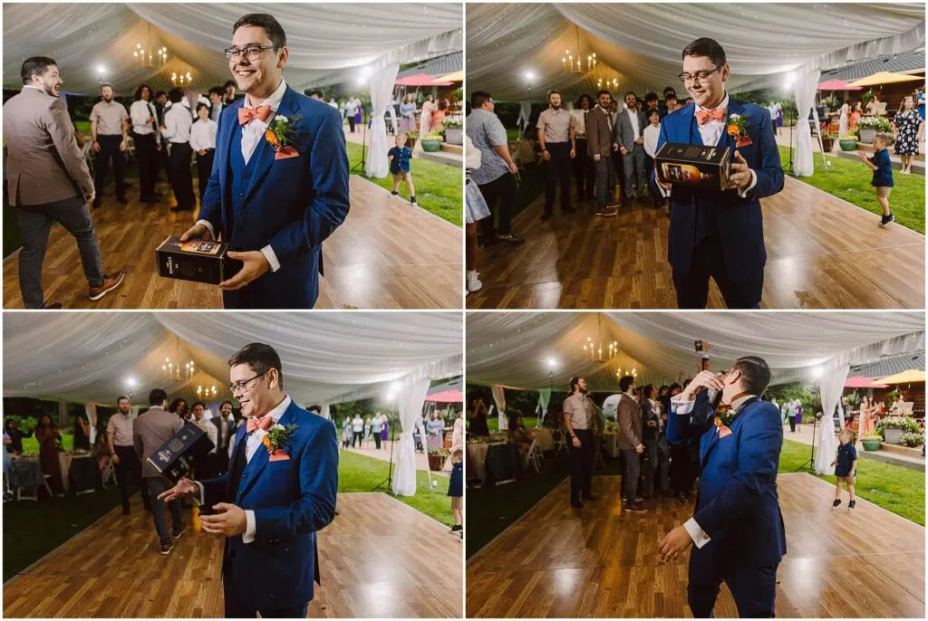Snohomish Wedding Photographer GSquared Weddings A man in a blue suit with a boutonniere stands in a tented outdoor area likely at a backyard wedding holding a black box He gestures animatedly to an attentive group The wooden ground hints at the festive mood as attendees enjoy the celebration dressed in formal attire Serving Seattle Snohomish and Washington State Snohomish Wedding Photographer GSquared Weddings A man in a blue suit with a boutonniere stands in a tented outdoor area, likely at a backyard wedding, holding a black box. He gestures animatedly to an attentive group. The wooden ground hints at the festive mood, as attendees enjoy the celebration dressed in formal attire. Serving Seattle, Snohomish and Washington State