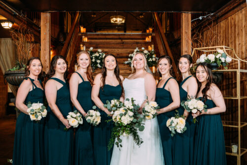 Bride and bridesmaids in front of the indoor staircase at lord hill farms