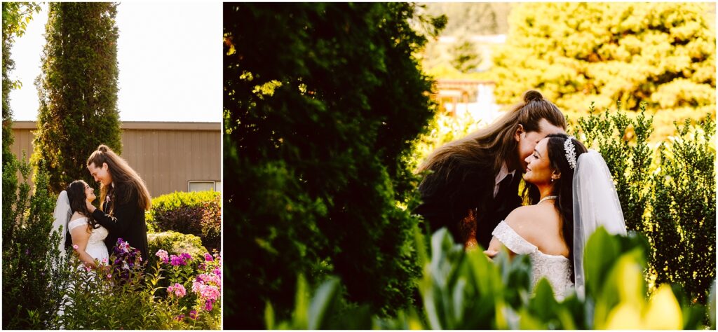 Bride and groom embrace in a sunny garden with pink flowers and tall hedges in the background
