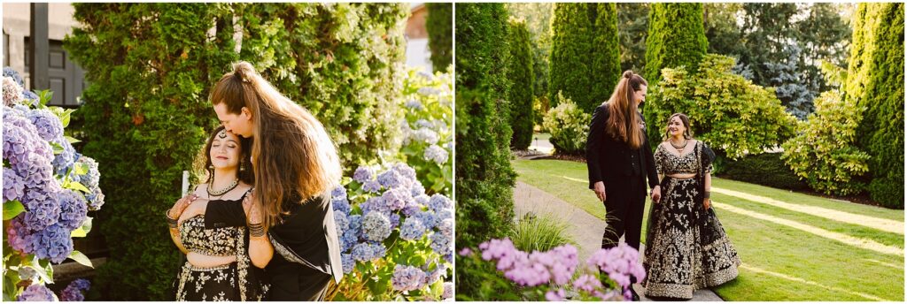 Couple in a garden with purple hydrangeas the man leans to kiss the woman's head as she smiles.