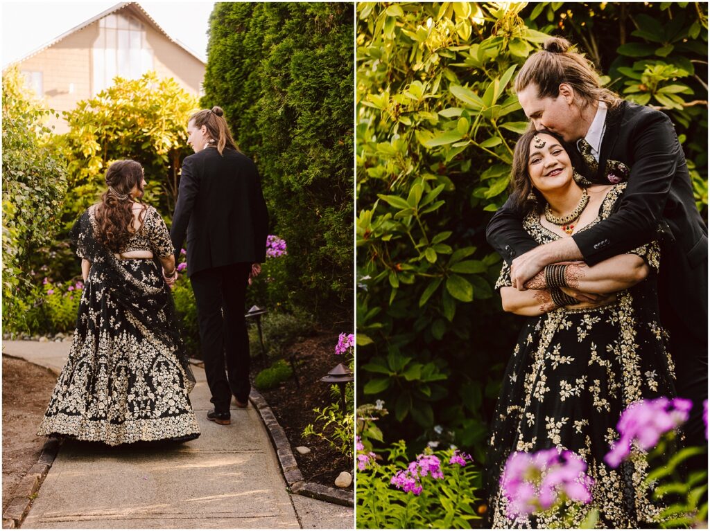 Couple walking hand in hand down a garden path the woman in a black and gold embroidered gown far from the camera
