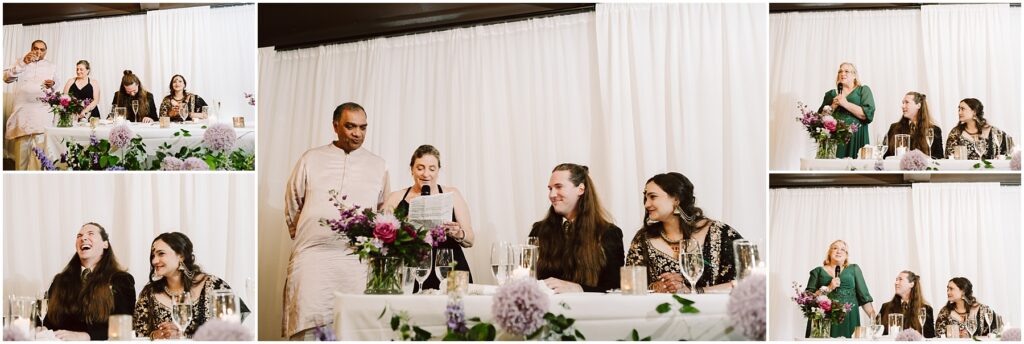 Group of people at a head table during a formal reception a woman speaks into a mic while others listen flowers in front