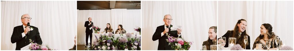 Older man in a black suit and tie speaks into a microphone at a wedding reception against a white draped backdrop
